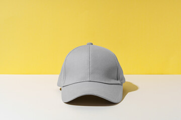 Baseball hat against yellow background in studio