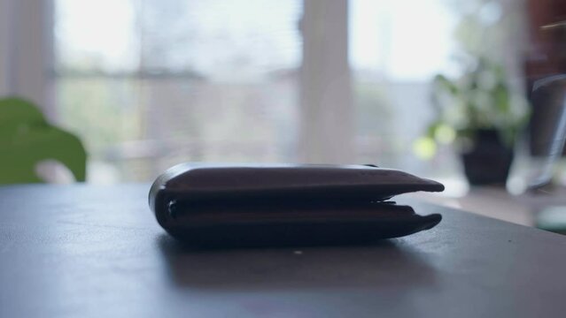 A man puts keys and a wallet off a table