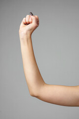 Raised Human Arm Exhibiting Strength and Determination Against a Neutral Background