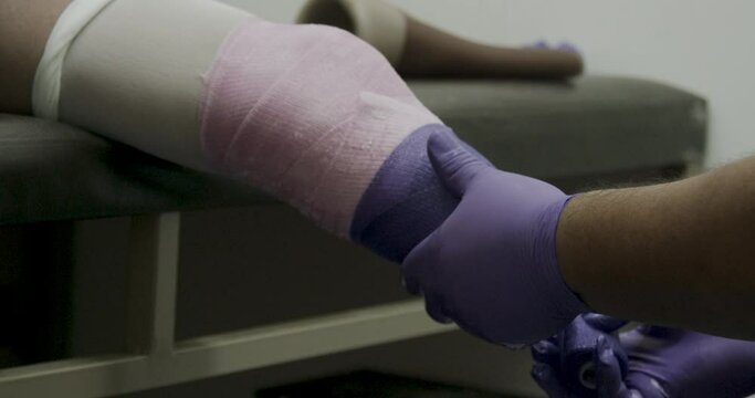 Close up on amputated leg being wrapped in bandages