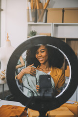 Fashion blogger concept, Young Asian women selling clothes on video streaming.Startup small business SME, using smartphone or tablet taking receive and checking in office