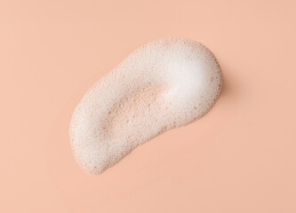 White skincare cleansing foam swatch on a pink background