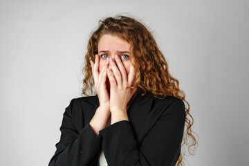 Young Woman Covering Face With Hands in Studio