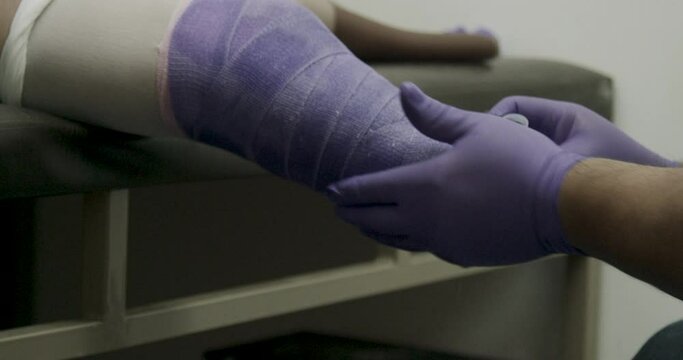 Doctor finishes wrapping bandages around amputees leg