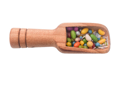 sweet sugar spreading pastry decoration on wooden spoon, Sweet and colourful traditional Jeeraka midai, Spice color Fencel insulated