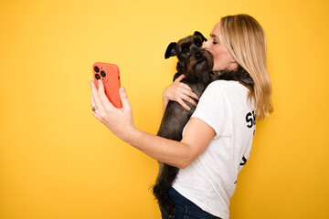 Close up young owner woman with her best friend schnauzer dog wears casual clothes do selfie shot...