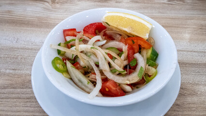 A seasonal salad with spring onions, tomatoes and cucumbers