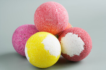 Multi-colored bath bombs on a light pastel background. Photo