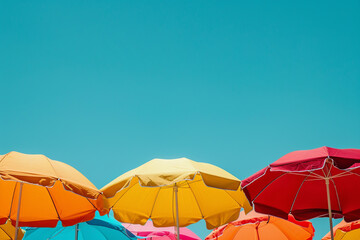 Colorful beach umbrellas against a blue cloudy sky