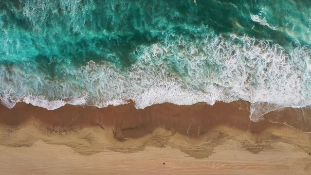 Top View Of Ocean Waves Splashing On Sandy Shore. Manhattan Beach In California, USA. aerial, slow motion