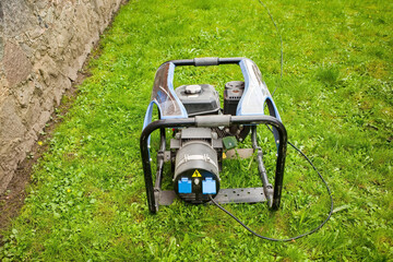 Portable electric generator on the green grass outdoors