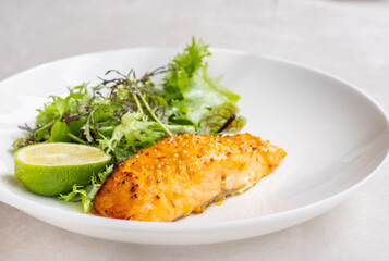 salmon steak with green salad and lime on restaurant table.woman girl holding wine wine glass in hand. food and drink business.