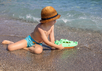 cute kid with hat on beach against sea or is having fun in summer vacation.boy with snorkel, diving...