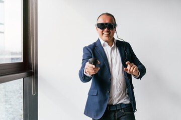 A businessman in a suit uses a VR headset and a controller, engaging with virtual reality...