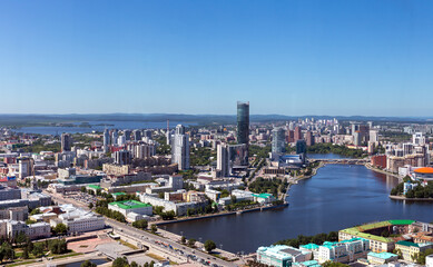 Above view of central part of modern city with skyscrapers and residential buildings. River and...
