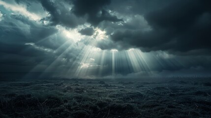 Conceptual image of hope with a sunbeam shining through clouds onto a dark landscape