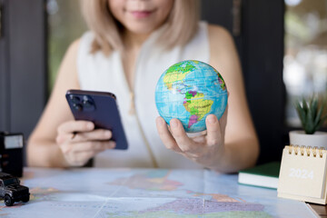 Woman traveler use smart phone for planning vacation trip and searching information or booking...