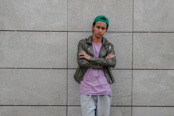 angry urban young man leaning on wall