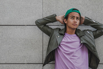 relaxed urban young man leaning on wall