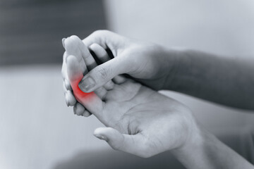 Woman suffering from hand and finger joint pain​ with red highlight.
