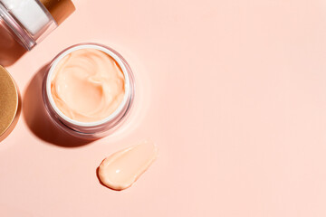 Skin care border - open jar and swatch of pink beauty cream