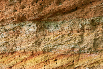 Ancient layers of clay and sand in layers of different colors. Background. Texture.