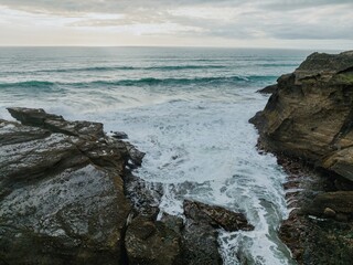 Waves washing over rock at sunset. Piha, Auckland, Auckland, New Zealand.