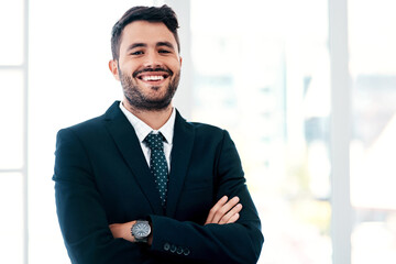 Portrait, happy and businessman with arms crossed in modern office with pride, suit and career in...