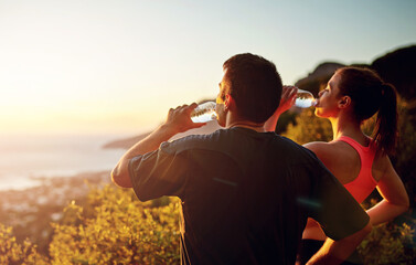 Man, woman and drinking water or mountain exercise for workout break with sunset, view or journey....