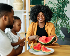 child family kitchen food boy son father mother watermelon fruit slice summer organic meal fun preparing healthy diet eating home black