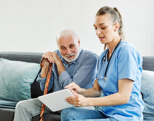 nurse doctor senior care tablet computer technology showing caregiver help assistence retirement home nursing elderly man