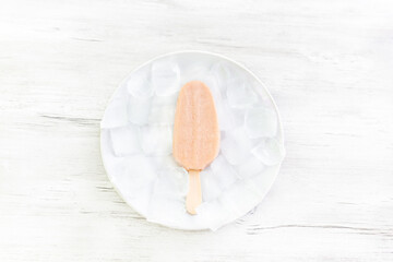 Berry ice cream on a stick with ice. White background. 