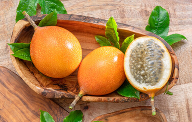 Granadilla fruits with leaves on wooden table.  Top view.