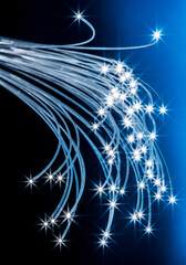 Bundle of optical fibers with lights in the ends. Blue background.