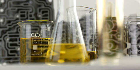 Test tube chemistry flask against background of hydroblock acp with yellow liquid purified oil from recycling and lubricating materials sale closeup