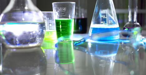 Chemical industry bulb with blue magenta pink liquid lab tubes stand on the table in the laboratory...