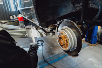 The rim is removed showing the rotor and caliper. Disc brake on car in process of new tire...