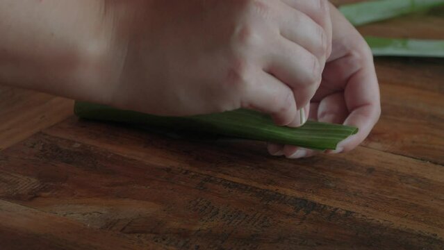 Hands preparing Sate lilit or sataya in banana leaves, famous Indonesian delicacy. This footage captures the culinary tradition and craftsmanship of Bali flavors .