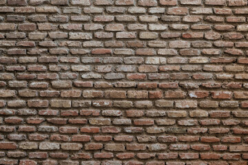 Abstract detail of an aging, red, brick wall with distinctive rows and pattern.