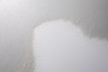 The image shows a gradient of silver glitter dispersing on a white background for a subtle effect