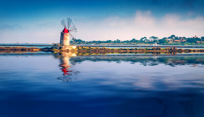 Old windmill of open-air Mothia / Mozia museum reflected in the calm waters of Mediterranean sea....