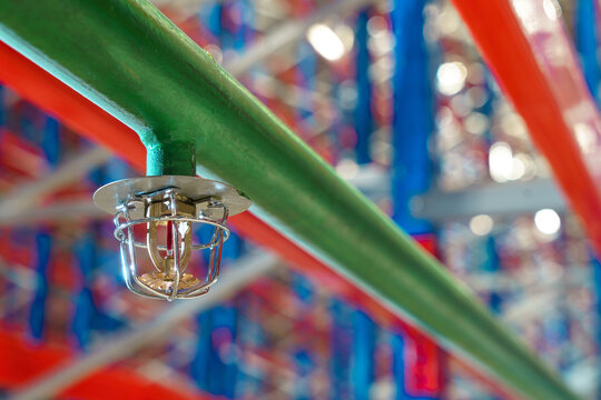 Fire sprinkler in a large warehouse with metal shelving