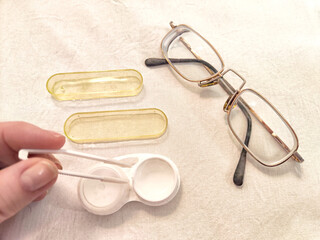 A set for contact lenses with a container, forceps, glasses. The concept of correcting myopia....