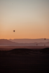 hot air balloons in sossusvlei national park at sunrise with the orange dunes as backdrop, namibia