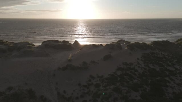 Aerial view of sand dunes and ocean at Ofir Beach in Esposende, Portugal during sunset.