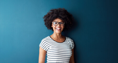 Black woman, portrait and smile with glasses, glow and confident on blue studio background. Girl,...