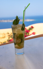 Mojito cocktail in a glass with a straw