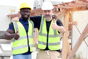 Happy harmony worker at workplace, smiling white foreman and African engineer cuddle around necks...