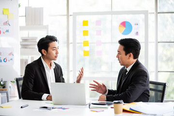 Professional Asian business adviser meeting to analyze and discuss the strategy of financial support of a tech company. Partnership start-up consultant, Indoor business client consultation concept.