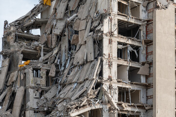 A detailed view of a partially collapsed building with visible damage, exposed floors, and debris....